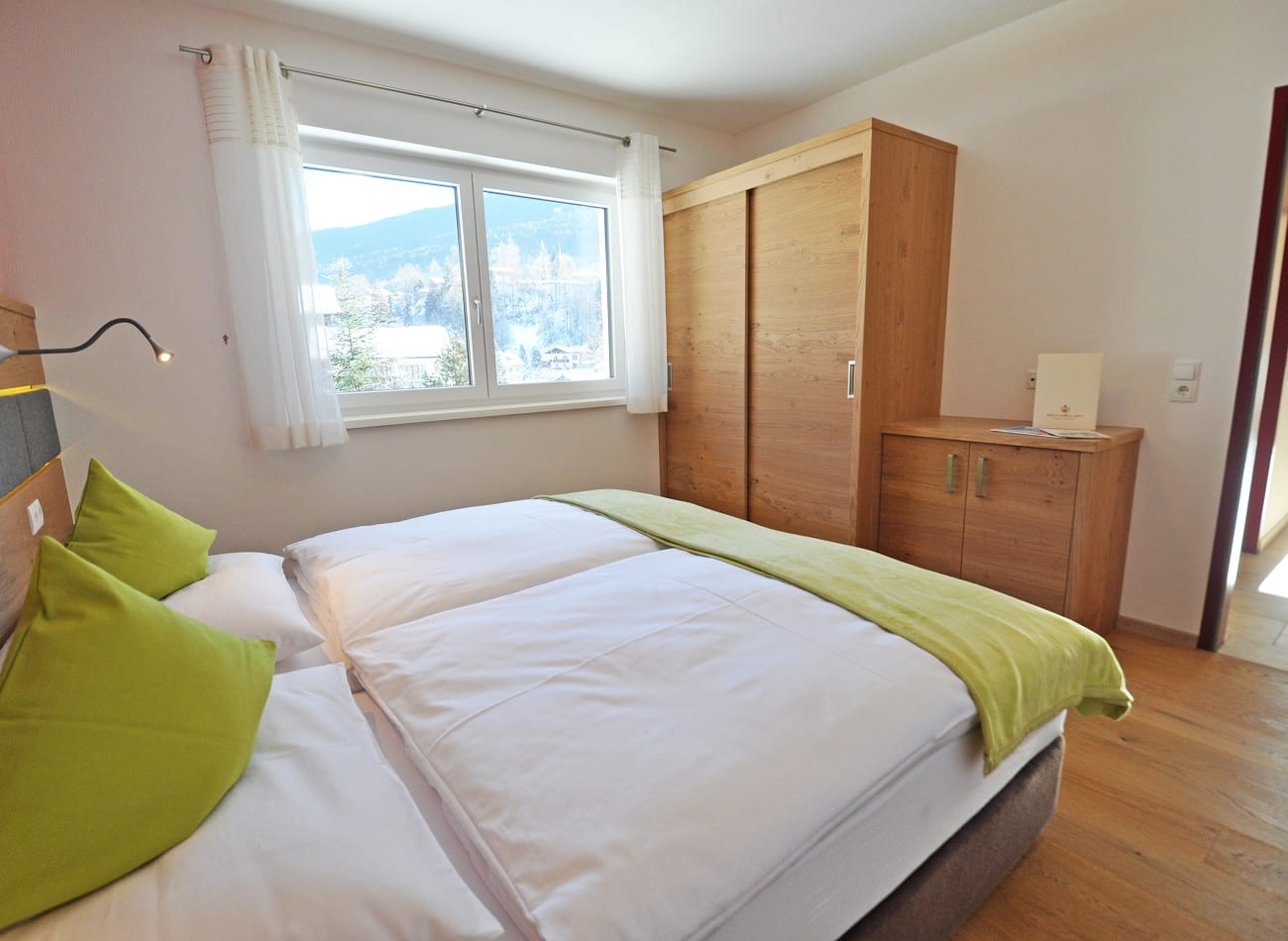 Helles Schlafzimmer im Classic Appartement E1 mit Doppelbett und Blick ins Gr&uuml;ne in den Appartements Schattauer in Wagrain